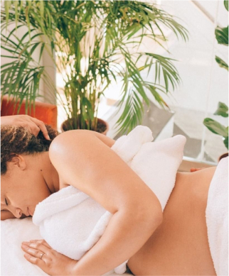 Pregnant woman lies on side on massage table 