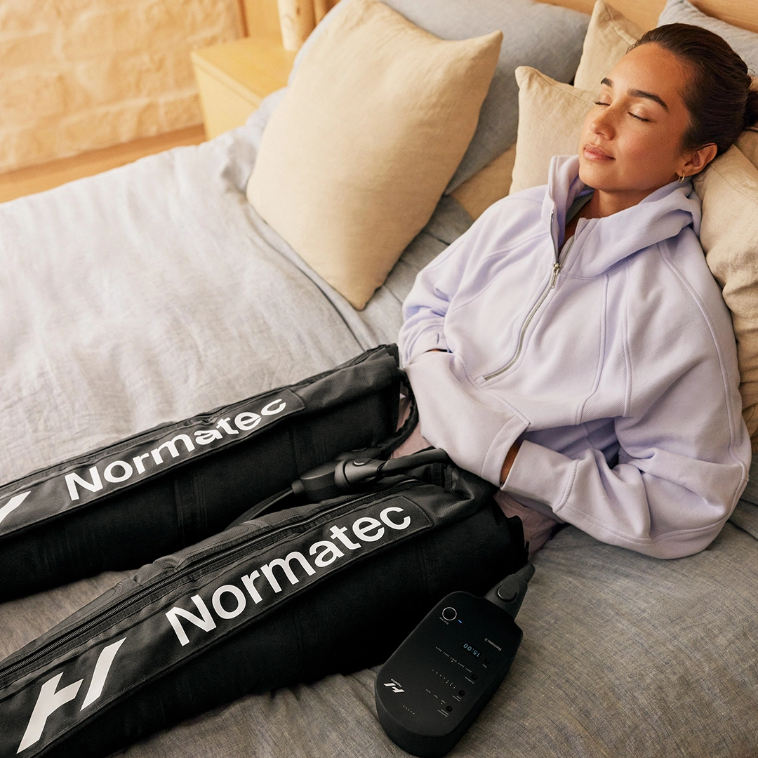Woman relaxes on bed during at-home compression therapy