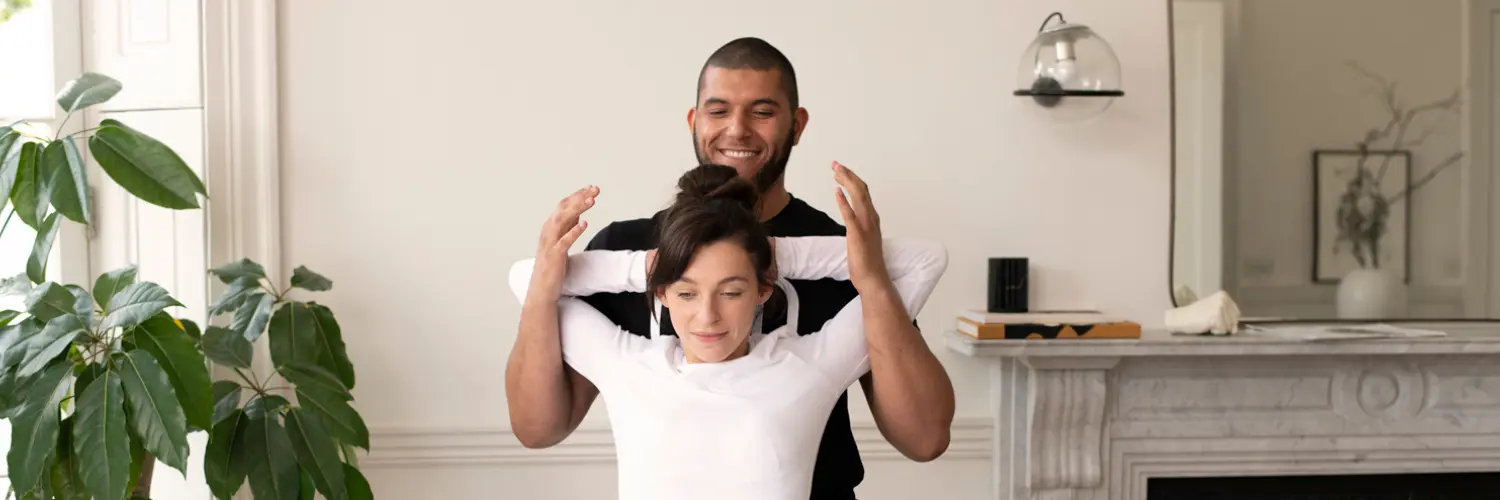 Stretchologist stretches a client's back during a home assisted stretching treatment