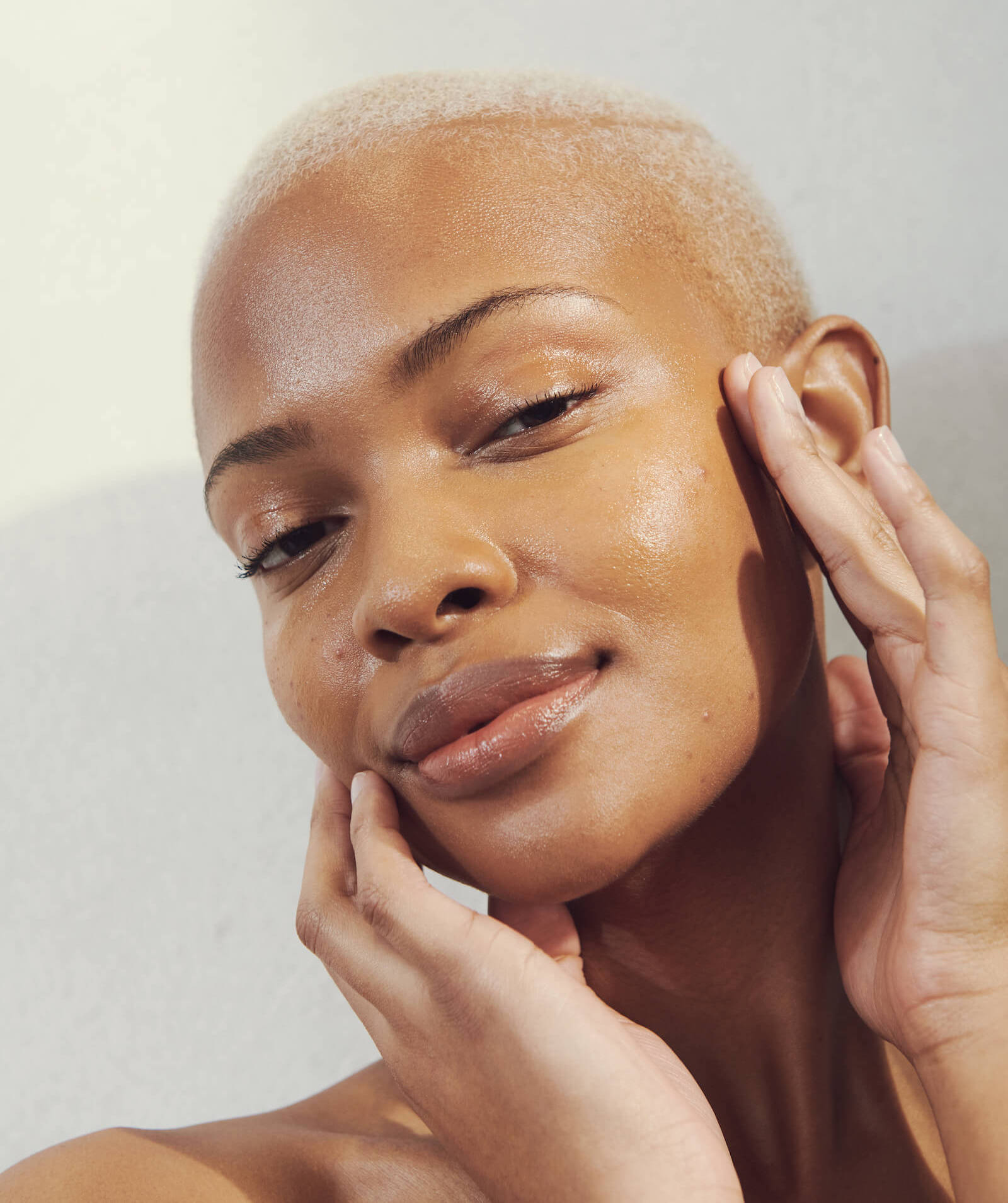 A woman with glowing, dewy skin demonstrates self facial massage techniques