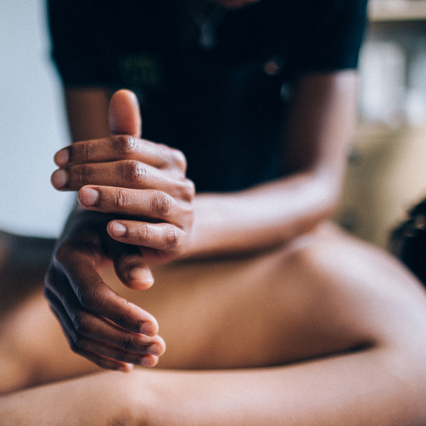 Therapist hands in foreground using elbows to massage client